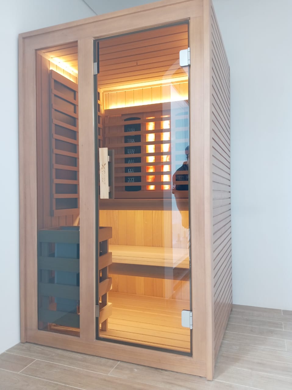 Indoor hybrid sauna combining infrared panels with a traditional stone heater