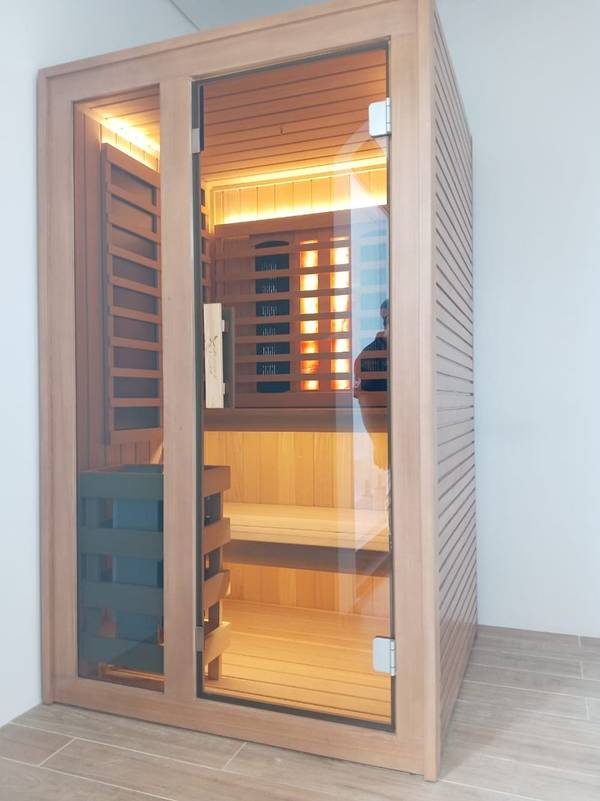 SaunaXperts Home 12 Indoor infrared sauna with full-spectrum heating panels glowing