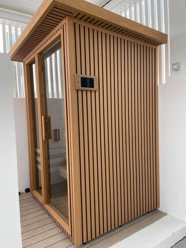 SaunaXperts Home 6 Modern slatted-wood outdoor sauna cabin with architectural roofline