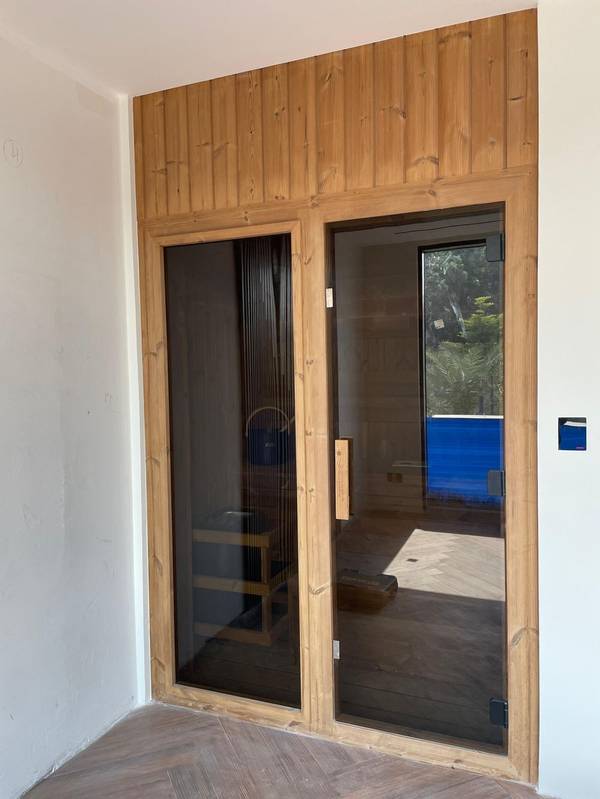 SaunaXperts Home 15 Sauna entrance positioned beside a private villa pool
